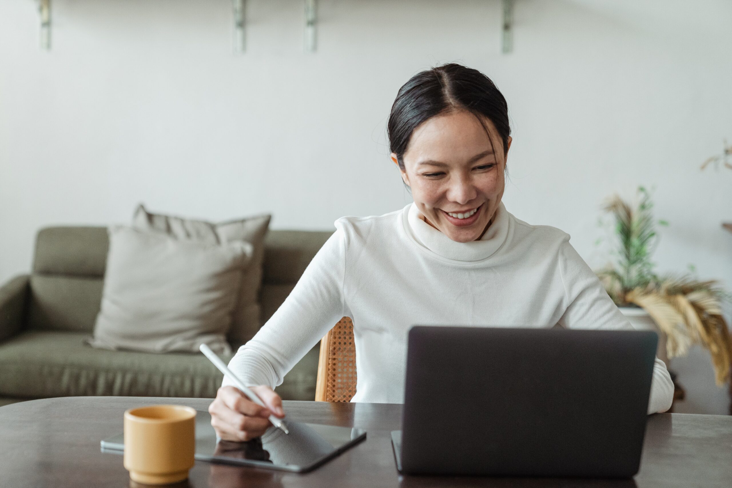 Female fintech employee working remotely on a laptop and tablet in the Asia Pacific region